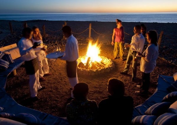 Moment de convivialité autour d'un grand feu sur la plage
